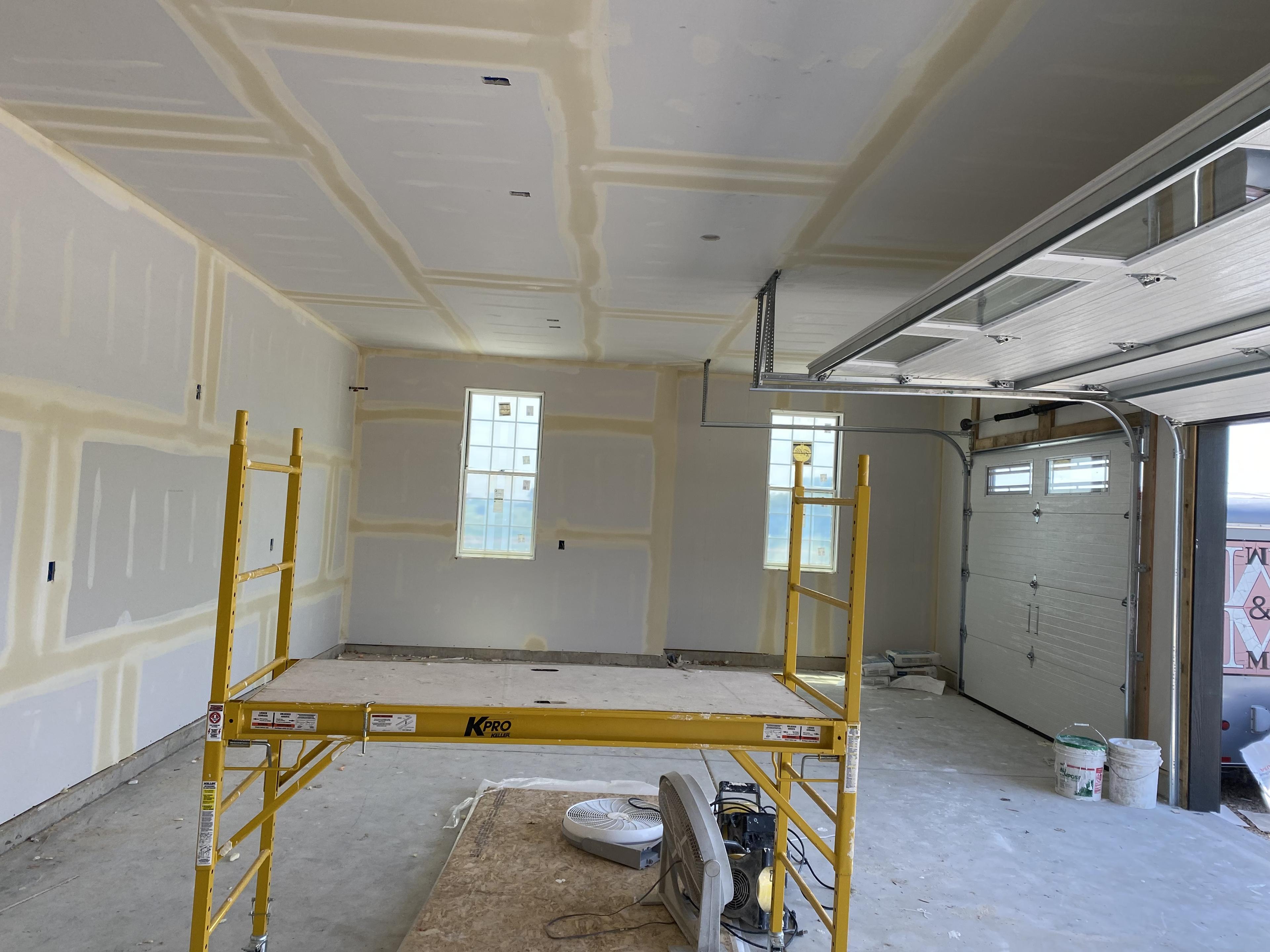 The inside of a garage, after drywall work.